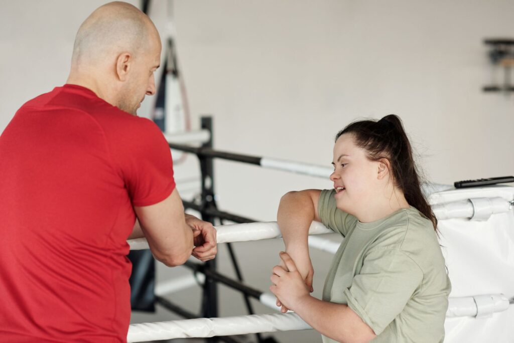 A coach and a young woman with Down syndrome talk between rounds at the gym