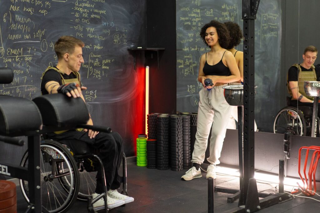 A trainer and a wheelchair user get ready for a workout together